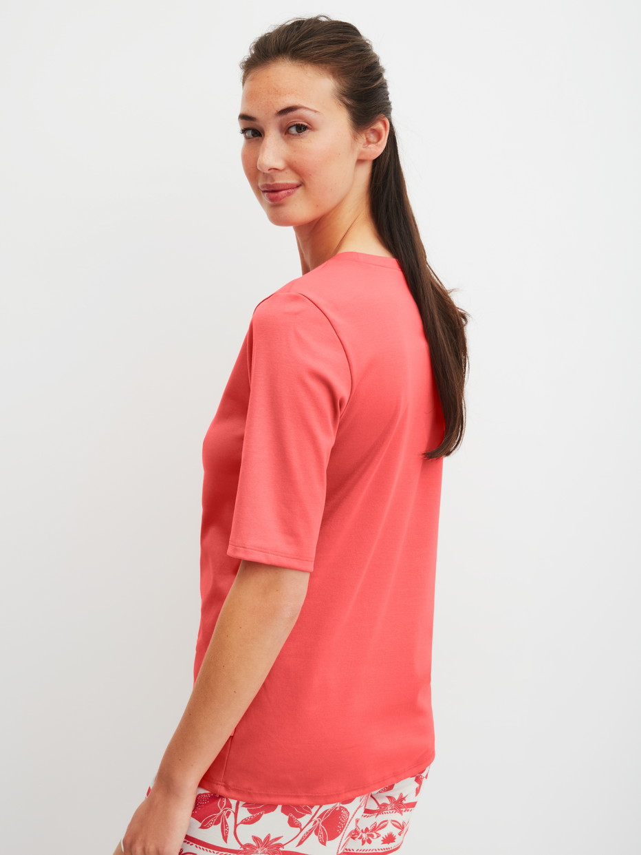 Damen-Model trägt Kurzarm-Shirt aus 100% Baumwolle in Orange, Einfarbig aus Serie Favourites Beach von CALIDA, Rückansicht