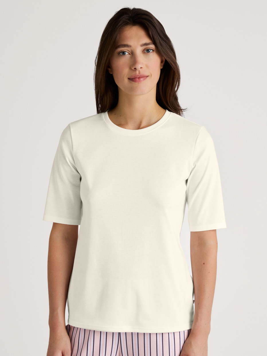 Women model is wearing Short-sleeved shirt made of 100% Cotton in White, Unicoloured from the Favourites Sleep series by CALIDA, Front view