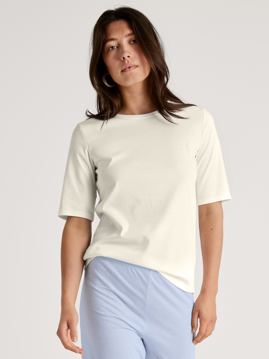 Women model is wearing Short-sleeved shirt made of 100% Cotton in White, Unicoloured from the Favourites Sleep series by CALIDA, Additional Image