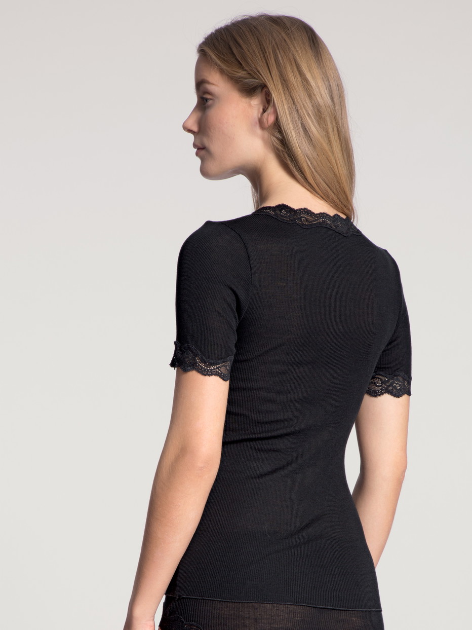 Damen-Model trägt Kurzarm-Shirt aus Wolle in Schwarz, Spitze aus Serie Richesse Lace von CALIDA, Rückansicht