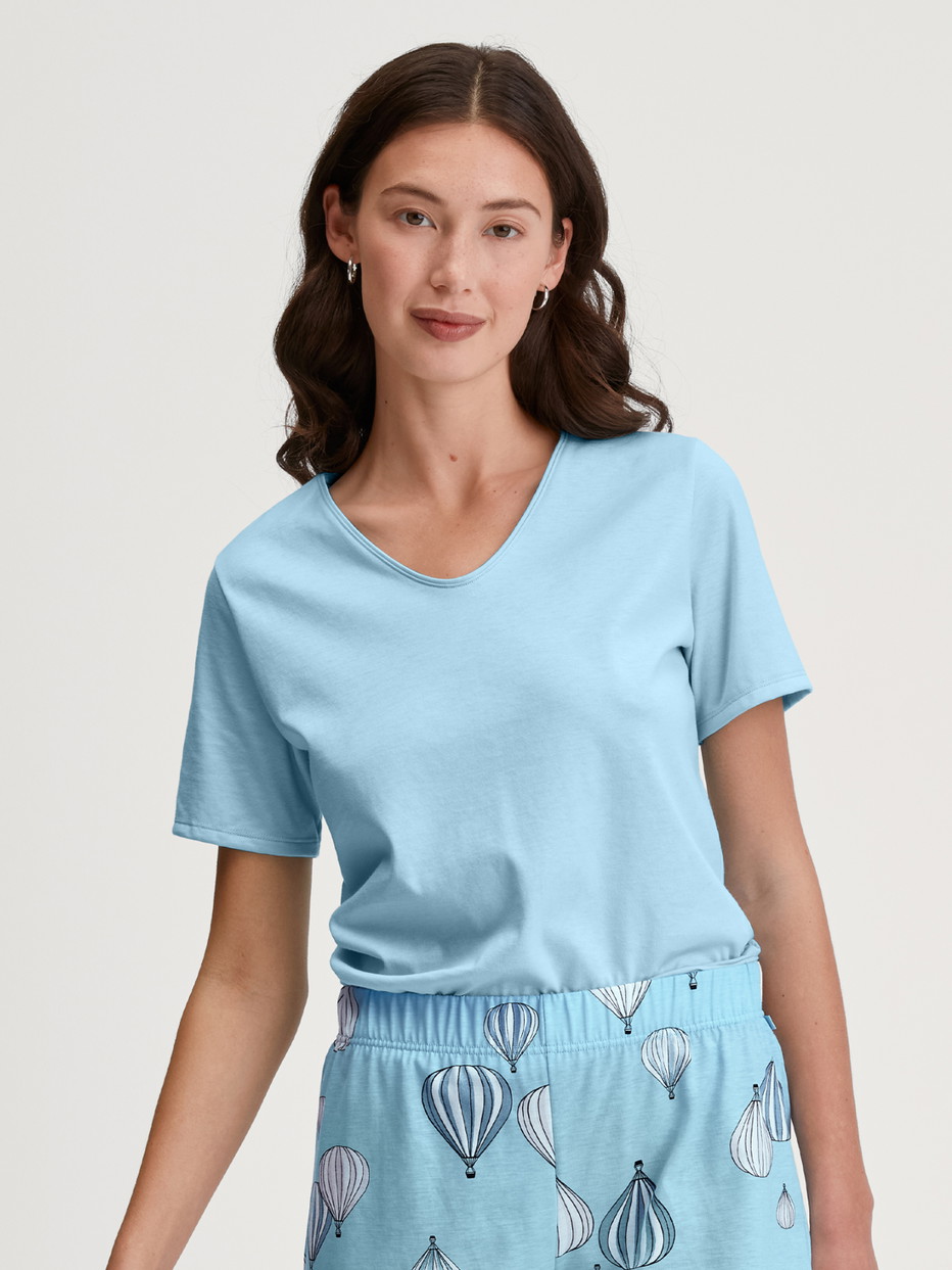 Damen-Model trägt T-shirt mit V-Neck aus 100% Baumwolle in Blau, Einfarbig aus Serie Favourites Journey von CALIDA, Vorderansicht