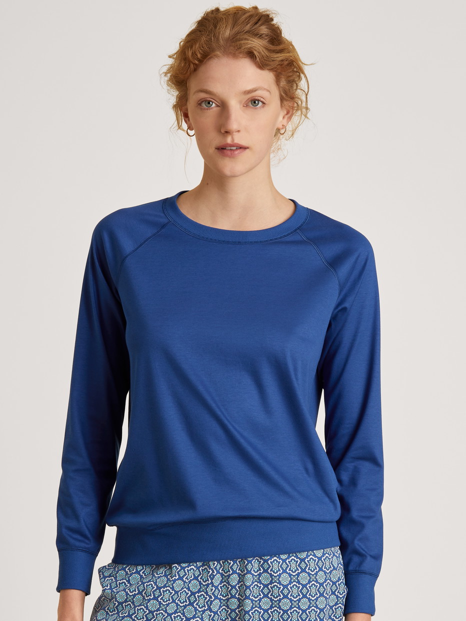 Women model is wearing Shirt long sleeve made of 100% Cotton in Blue, Unicoloured from the Favourites Energy series by CALIDA, Front view