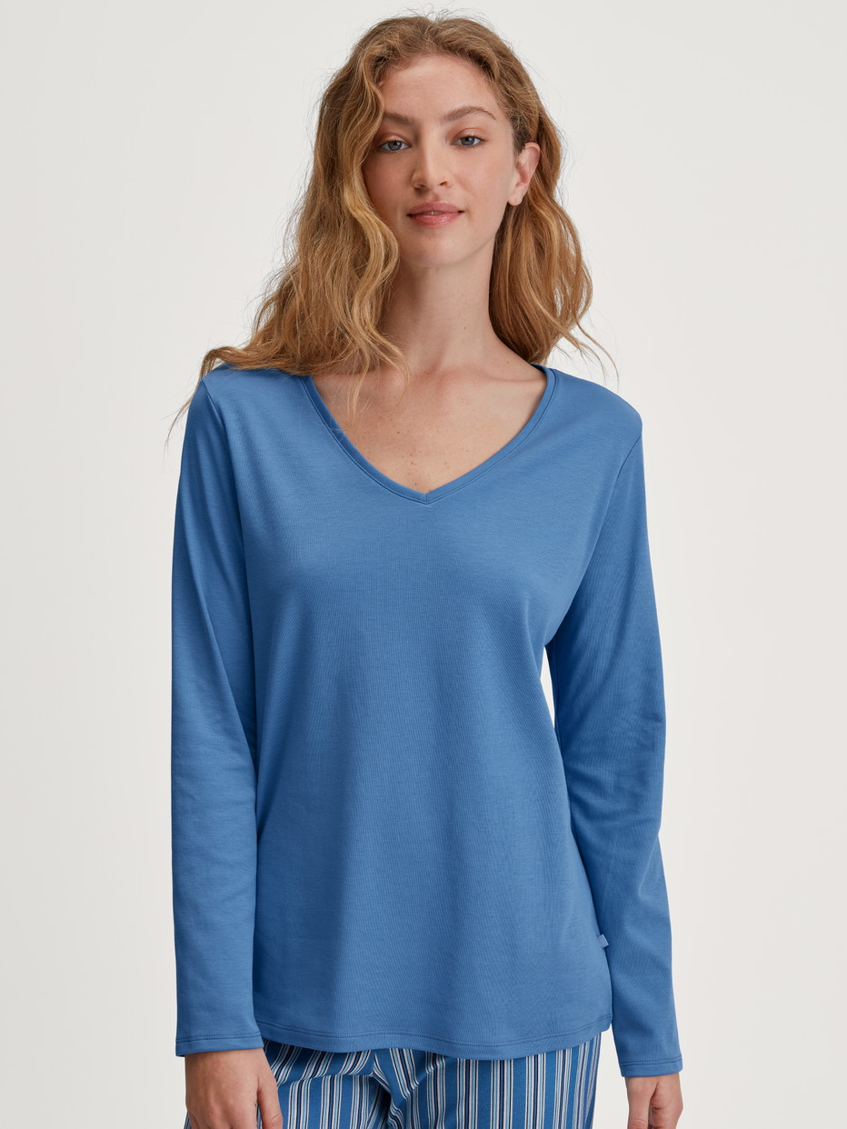 Damen-Model trägt Langarm-Shirt, V-Neck aus 100% Baumwolle in Blau, Einfarbig aus Serie Favourites Journey von CALIDA, Vorderansicht