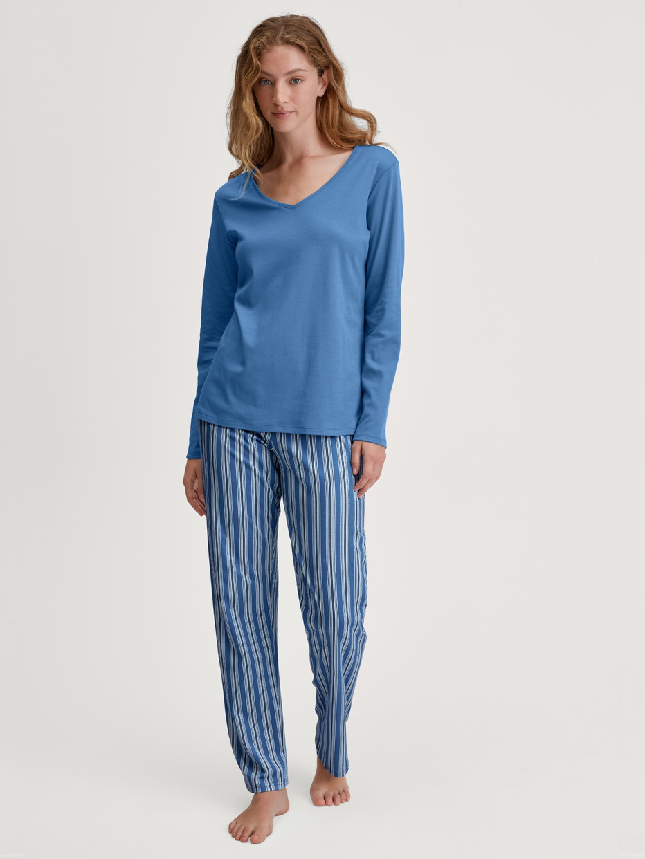 Damen-Model trägt Langarm-Shirt, V-Neck aus 100% Baumwolle in Blau, Einfarbig aus Serie Favourites Journey von CALIDA, Outfit