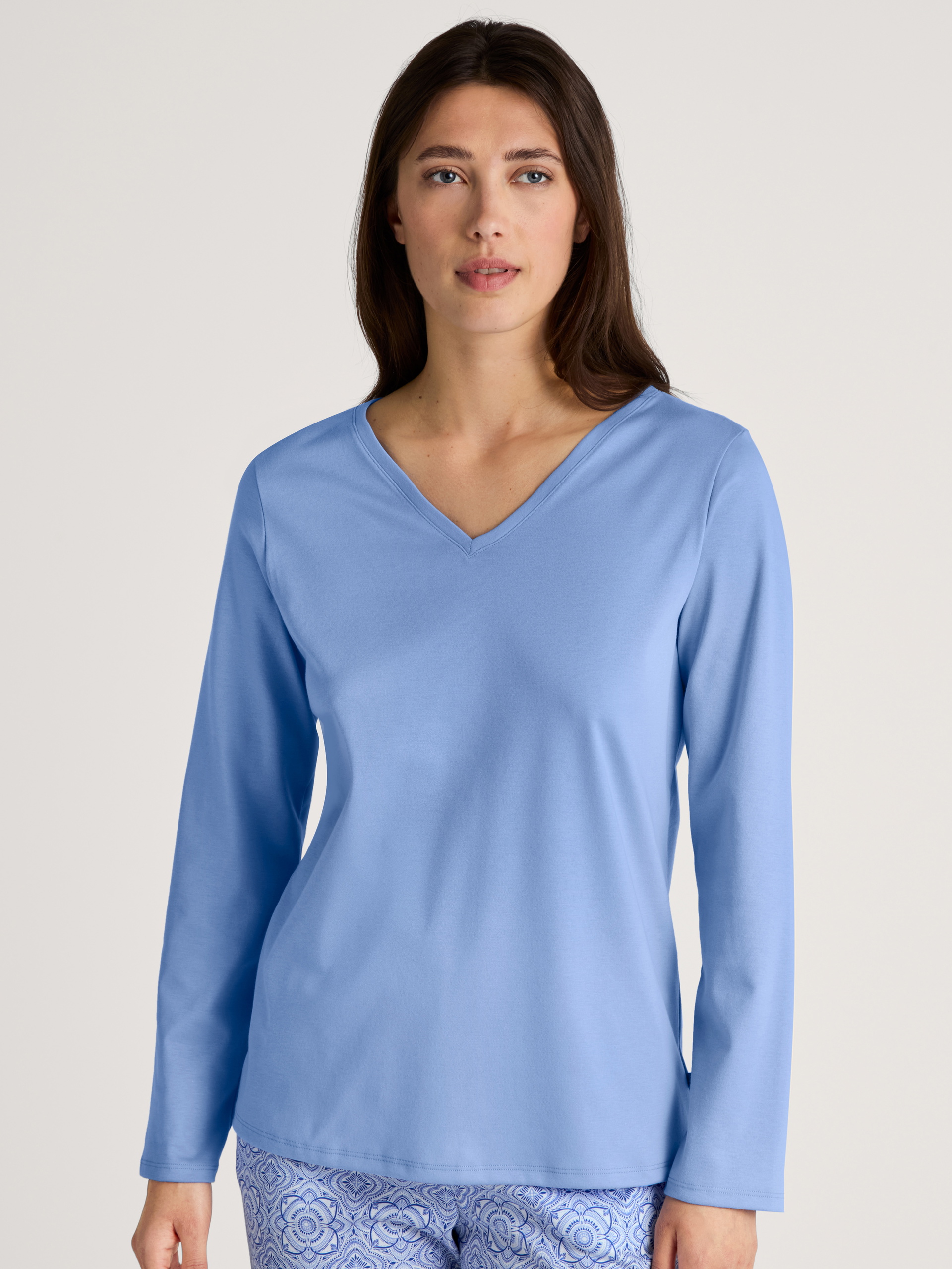 Damen-Model trägt Langarm-Shirt, V-Neck aus 100% Baumwolle in Blau, Einfarbig aus Serie Favourites Marine von CALIDA, Vorderansicht