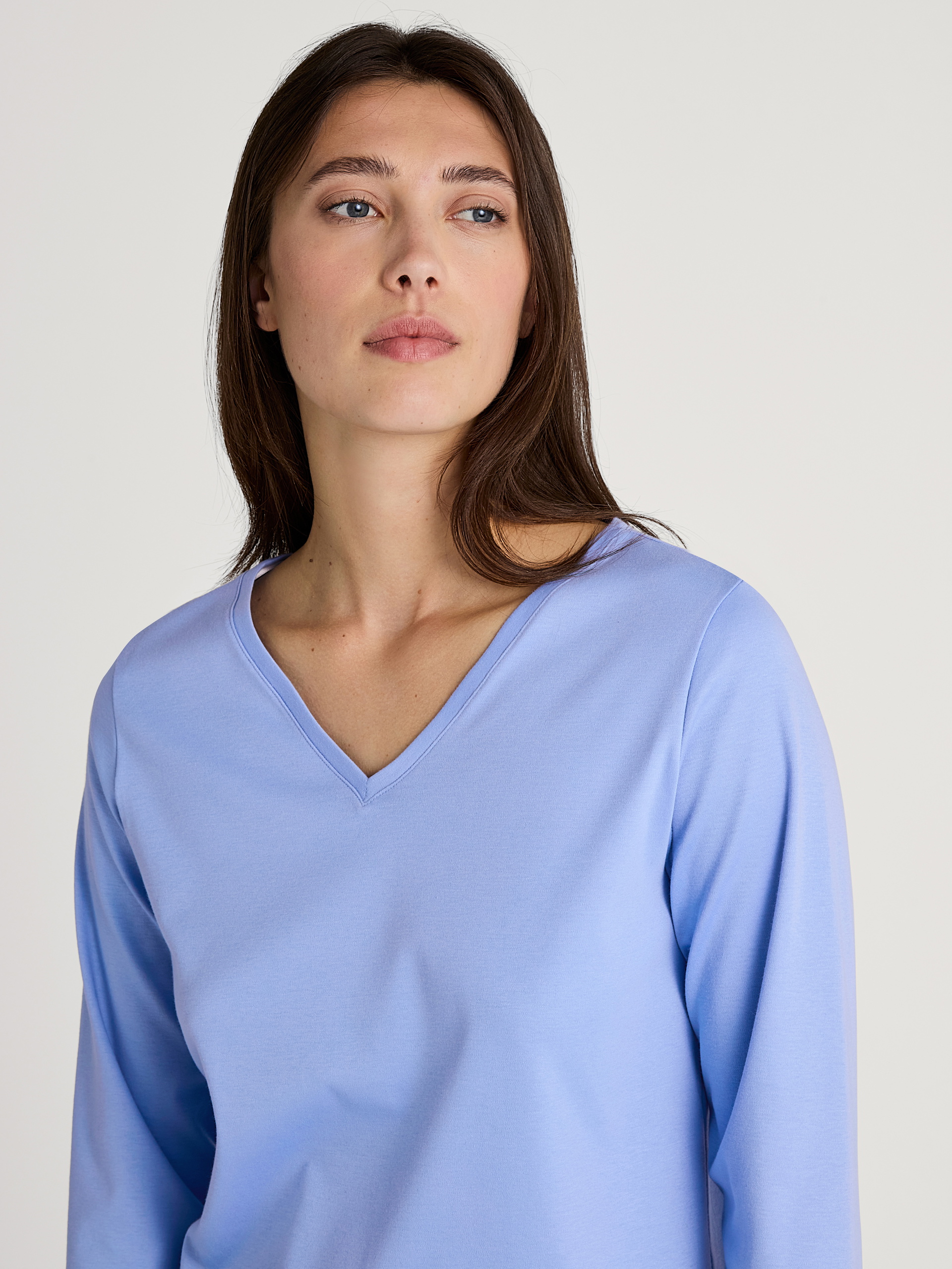 Damen-Model trägt Langarm-Shirt, V-Neck aus 100% Baumwolle in Blau, Einfarbig aus Serie Favourites Marine von CALIDA, Detail