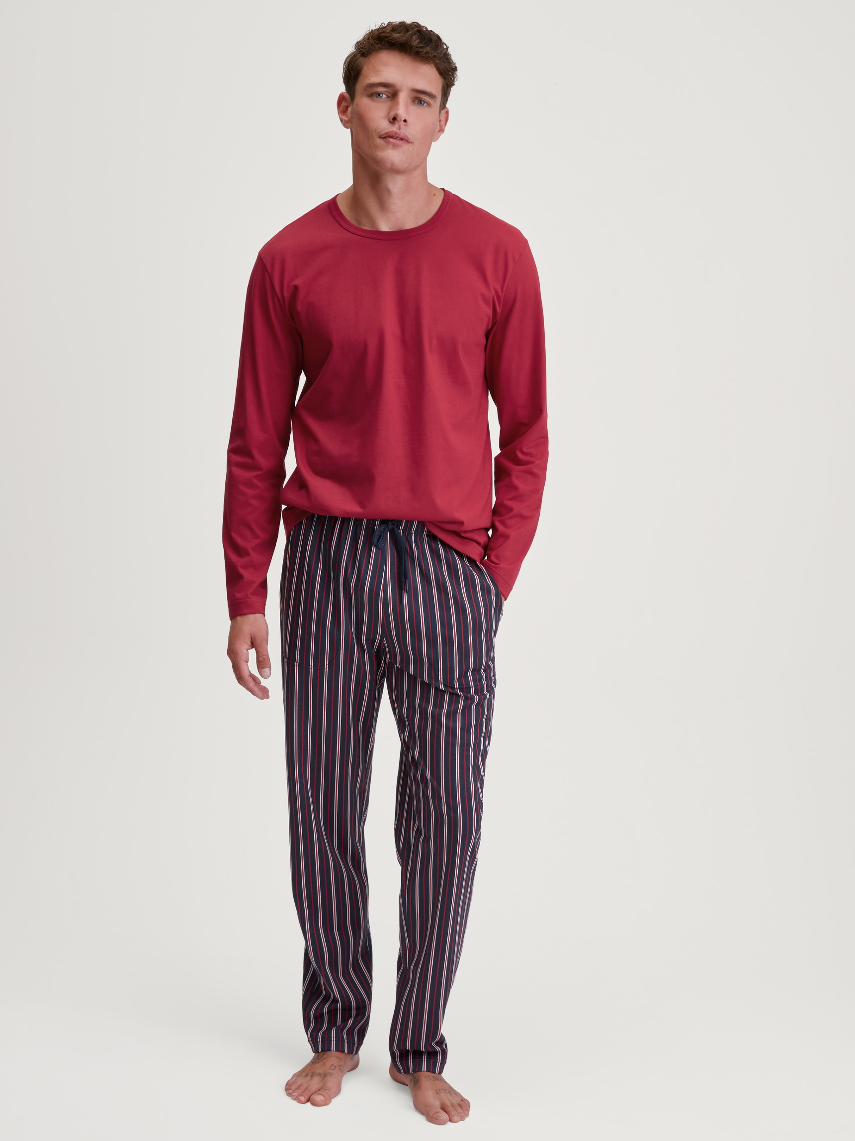Herren-Model trägt Langarm-Shirt aus 100% Baumwolle in Rot, Einfarbig aus Serie Remix Basic Sleep von CALIDA, Outfit