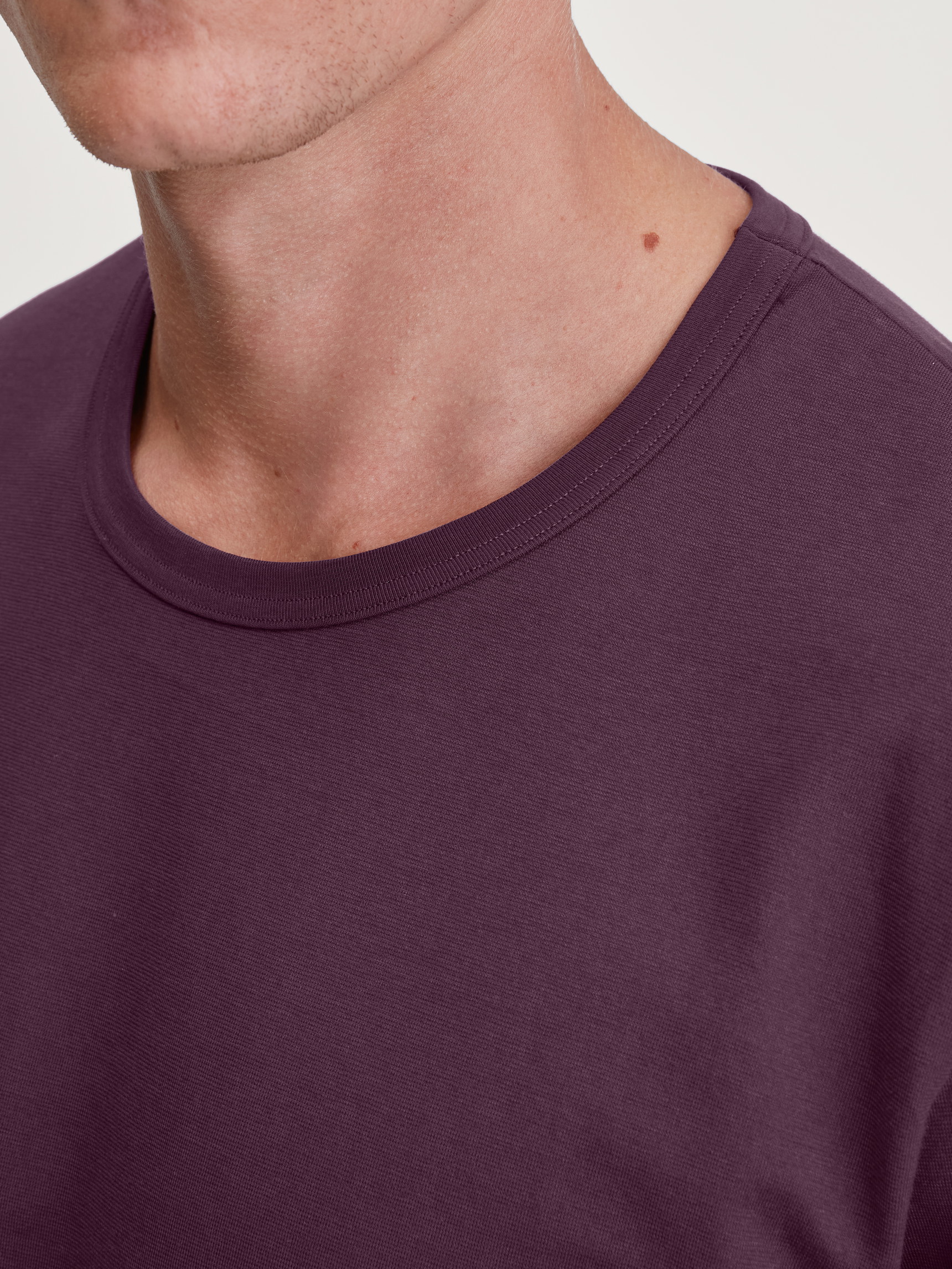 La modella / Il modello Uomo indossa Shirt a manica lunga in 100% cotone di colore Rosso, Tinta unita, della serie RMX Sleep Holiday di CALIDA, Dettaglio