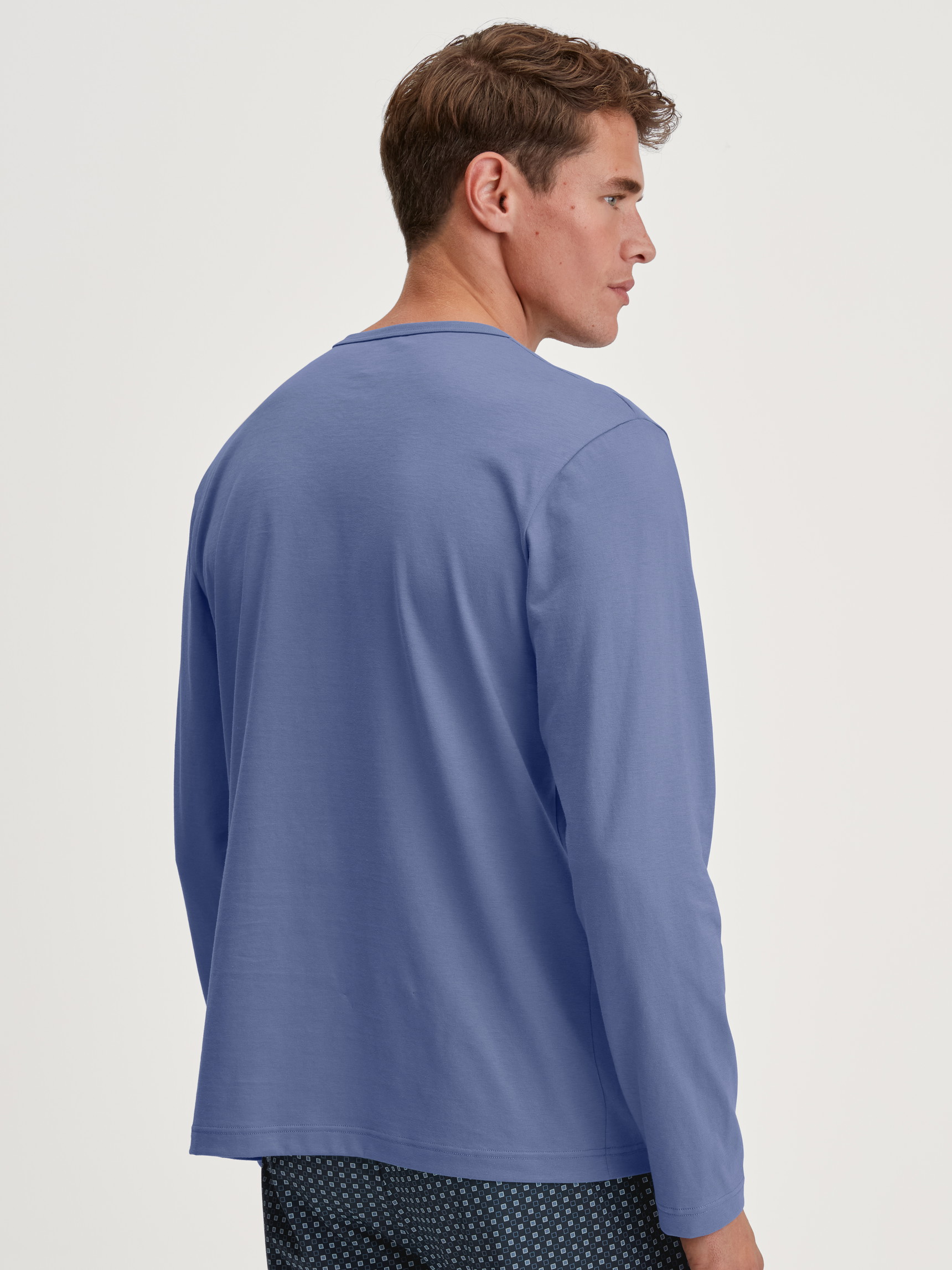 Herren-Model trägt Langarm-Shirt aus 100% Baumwolle in Blau, Einfarbig aus Serie Remix Basic Sleep von CALIDA, Rückansicht
