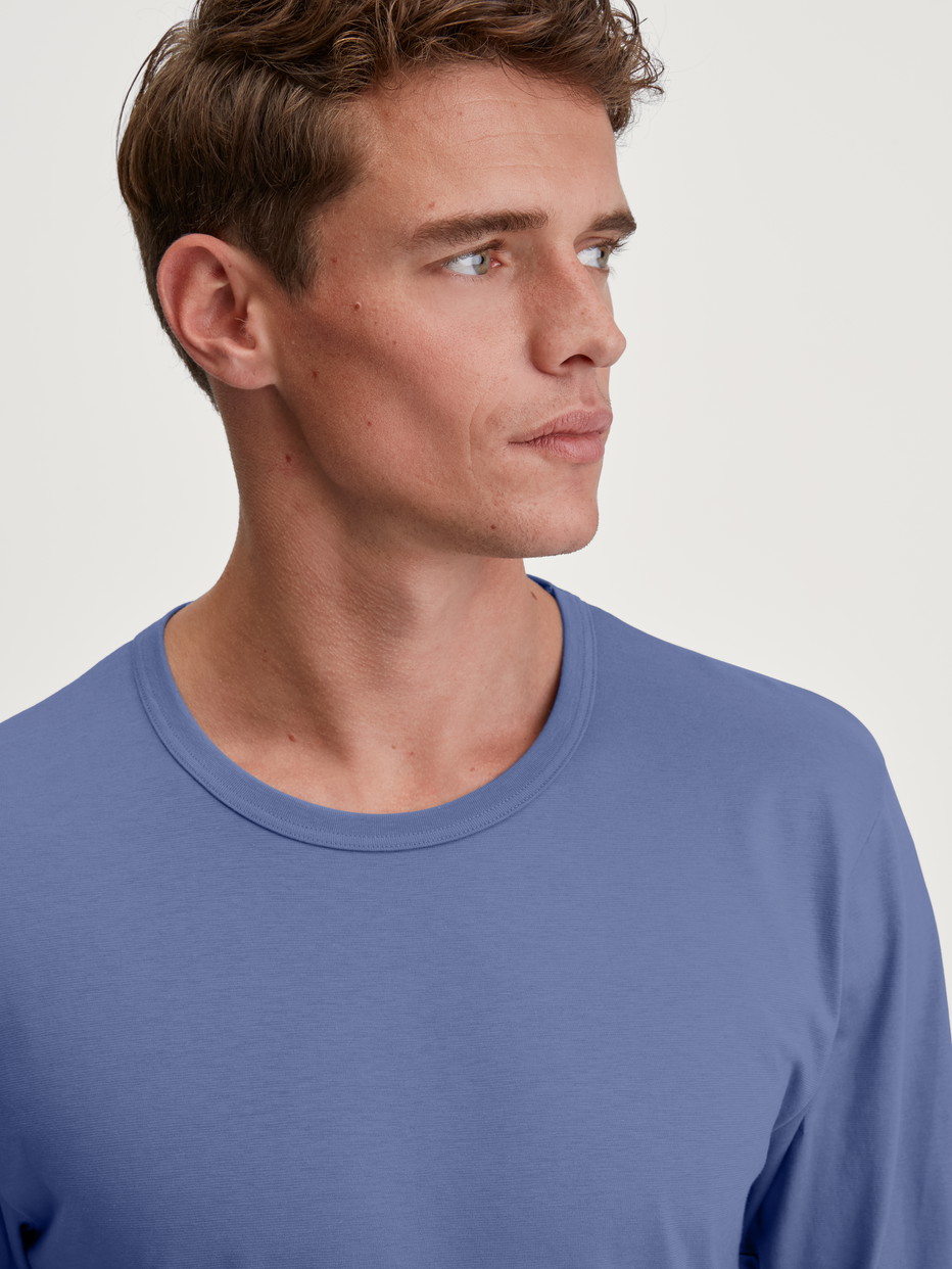 Herren-Model trägt Langarm-Shirt aus 100% Baumwolle in Blau, Einfarbig aus Serie Remix Basic Sleep von CALIDA, Detail