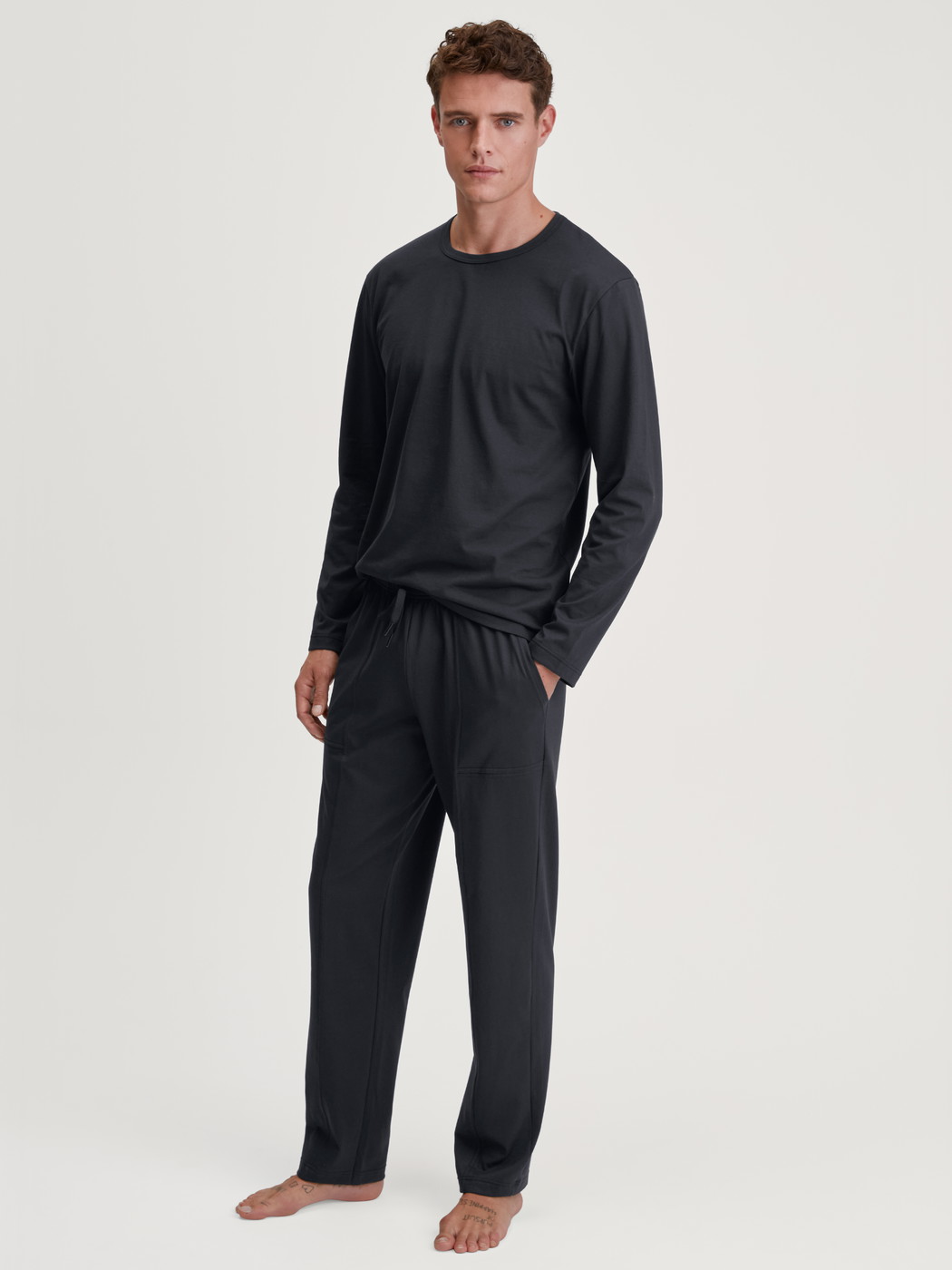 Men model is wearing Shirt long sleeve made of 100% Cotton in Black, Unicoloured from the RMX Sleep Leisure series by CALIDA, Outfit
