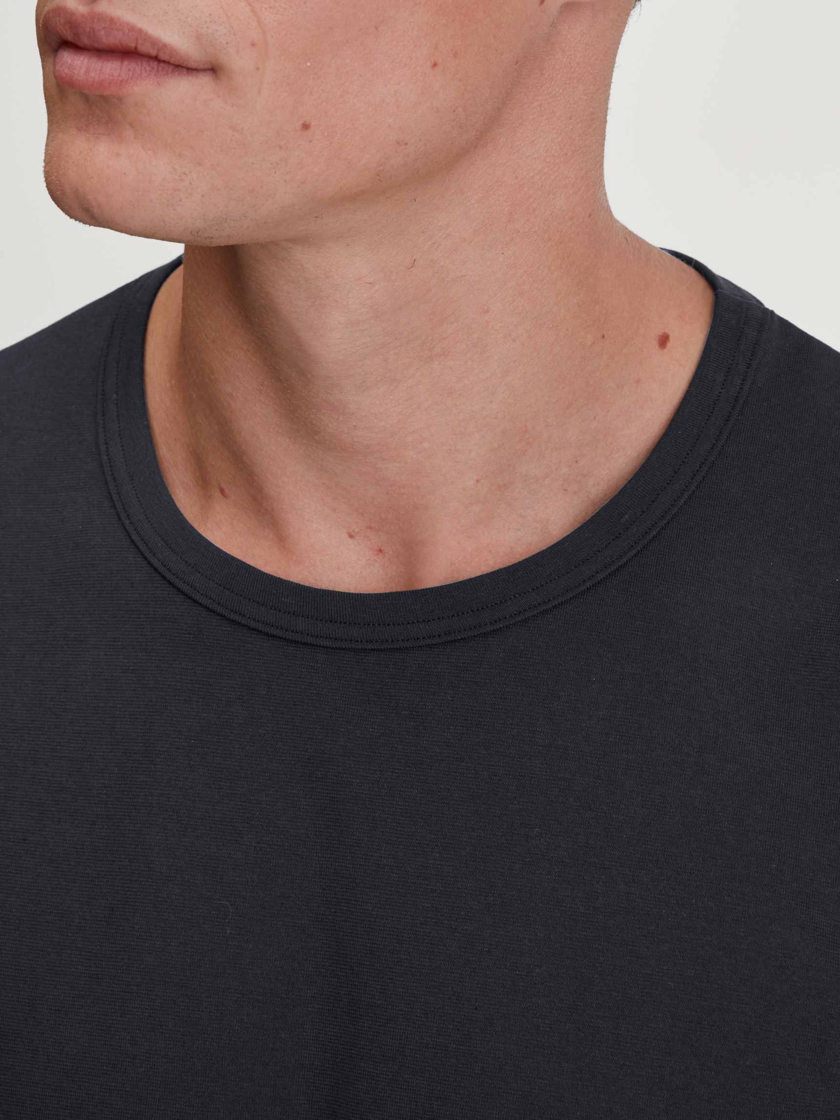 Herren-Model trägt Langarm-Shirt aus 100% Baumwolle in Schwarz, Einfarbig aus Serie RMX Sleep Leisure von CALIDA, Detail