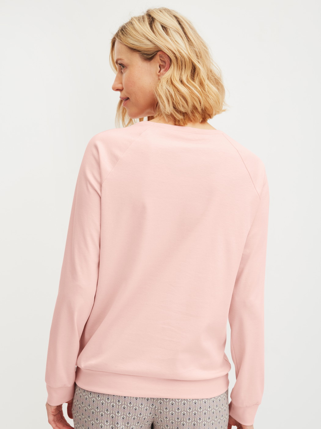 Women model is wearing Long-sleeve shirt with raglan sleeves made of 100% Cotton in Pink, Unicoloured from the Favourites Arts series by CALIDA, Back view