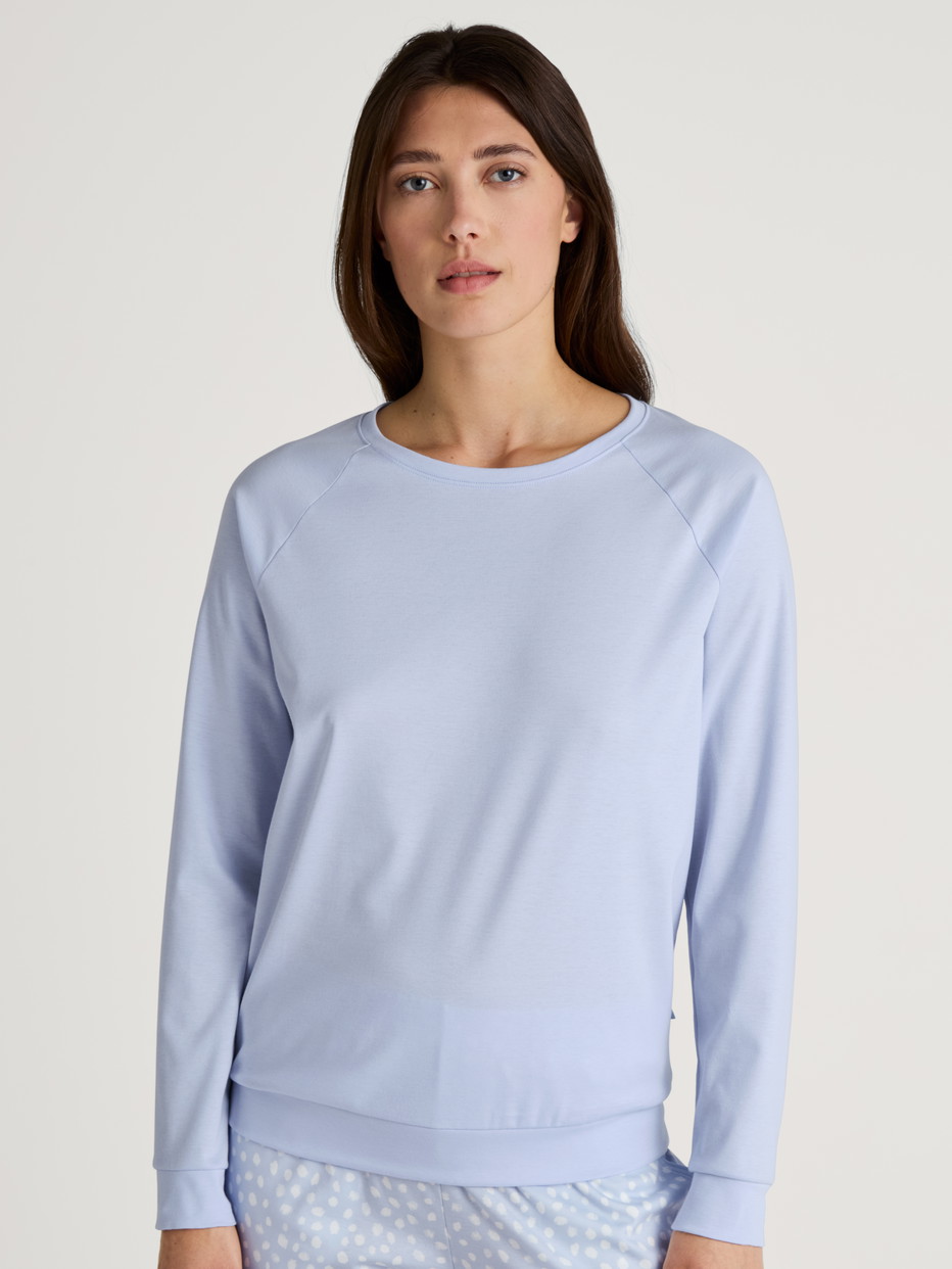 Women model is wearing Long-sleeve shirt with raglan sleeves made of 100% Cotton in Blue, Unicoloured from the Favourites Sleep series by CALIDA, Front view