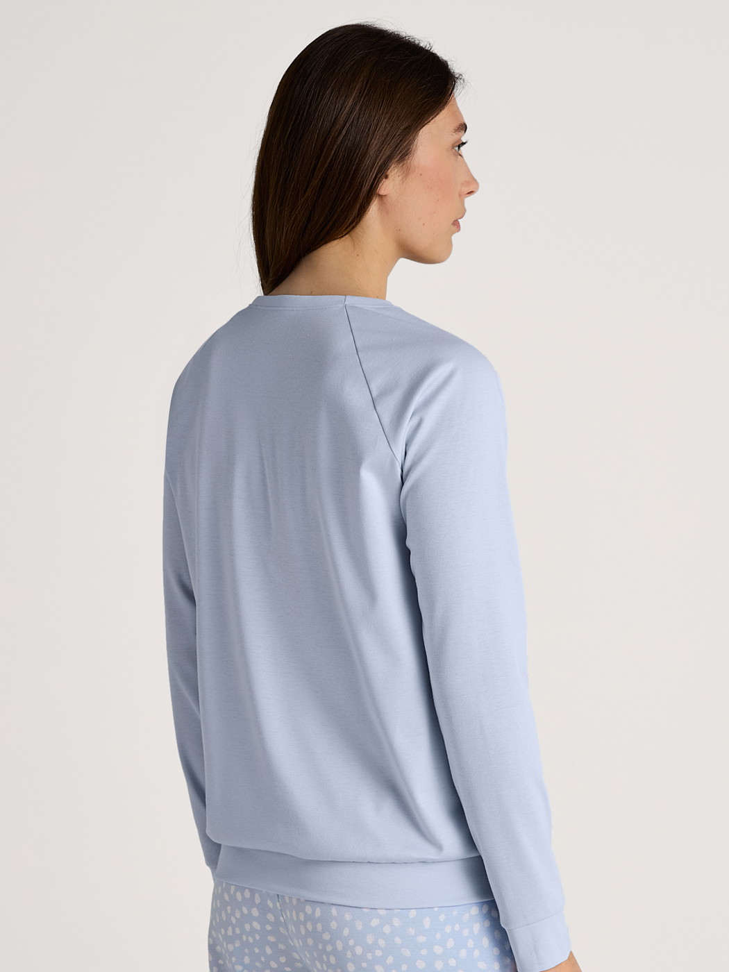 Women model is wearing Long-sleeve shirt with raglan sleeves made of 100% Cotton in Blue, Unicoloured from the Favourites Sleep series by CALIDA, Back view