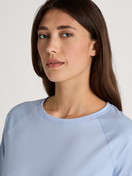 Women model is wearing Long-sleeve shirt with raglan sleeves made of 100% Cotton in Blue, Unicoloured from the Favourites Sleep series by CALIDA, Detail