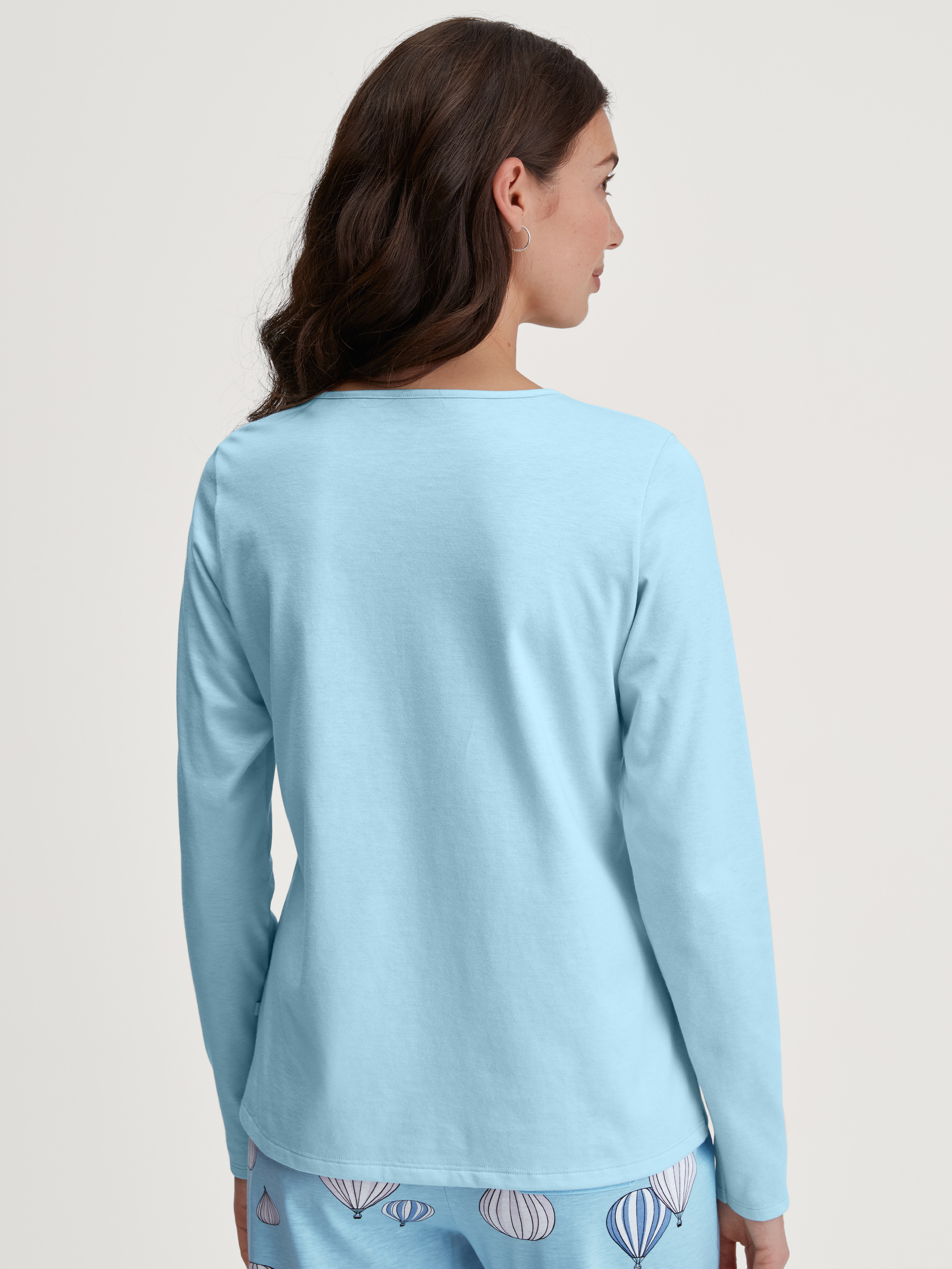 Damen-Model trägt Langarm-Shirt aus 100% Baumwolle in Blau, Einfarbig aus Serie Favourites Journey von CALIDA, Rückansicht