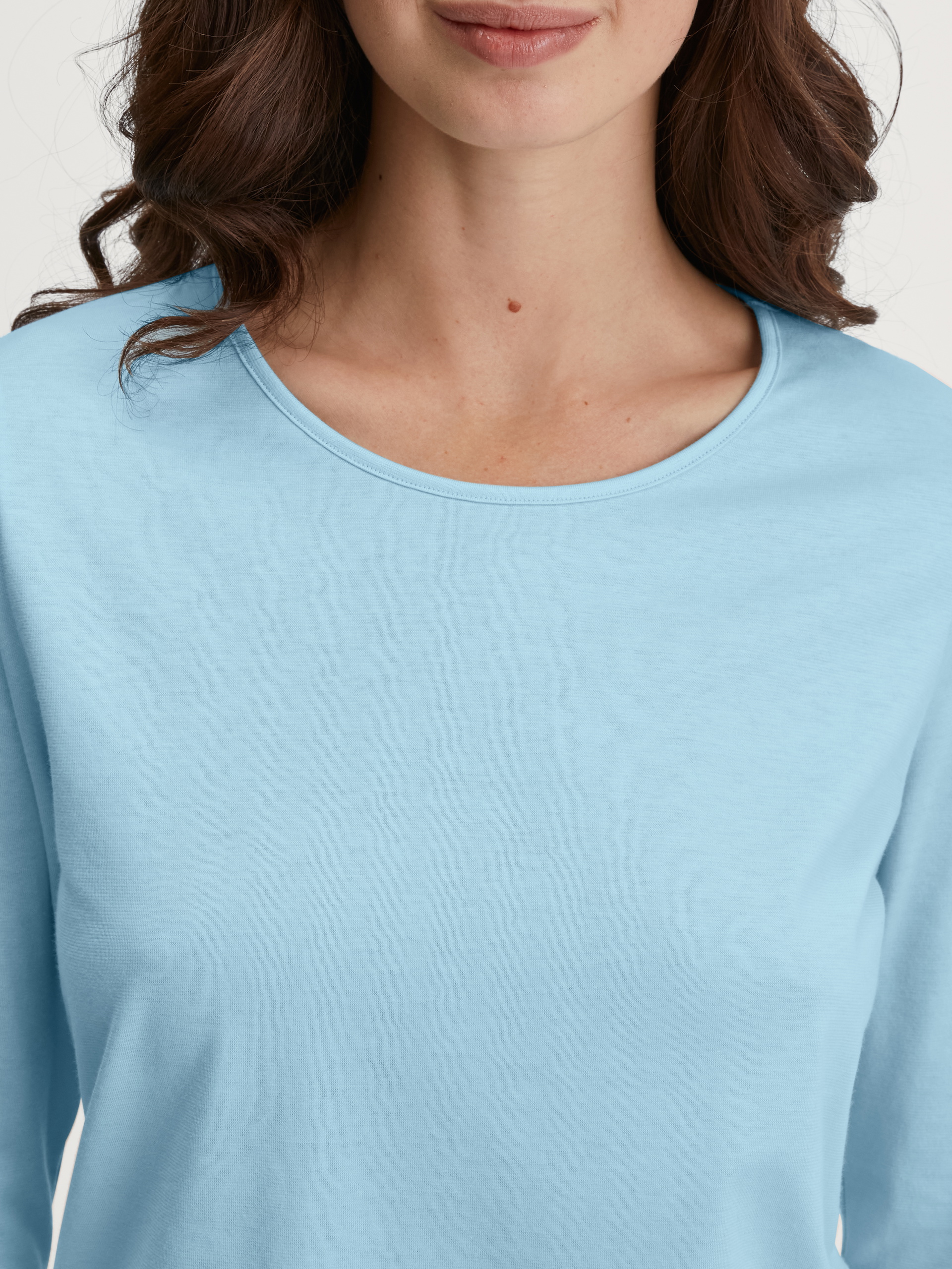 Damen-Model trägt Langarm-Shirt aus 100% Baumwolle in Blau, Einfarbig aus Serie Favourites Journey von CALIDA, Detail
