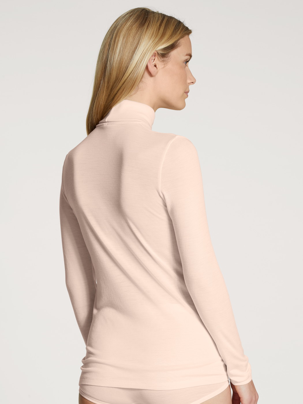 Women model is wearing Long-sleeve turtleneck shirt in wool-silk made of Swiss+Cotton in Beige, Unicoloured from the True Confidence series by CALIDA, Back view