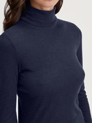 La modella / Il modello Donna indossa Maglia a maniche lunghe dolcevita in lana-seta in Lana di colore Blu, Tinta unita, della serie True Confidence di CALIDA, Dettaglio