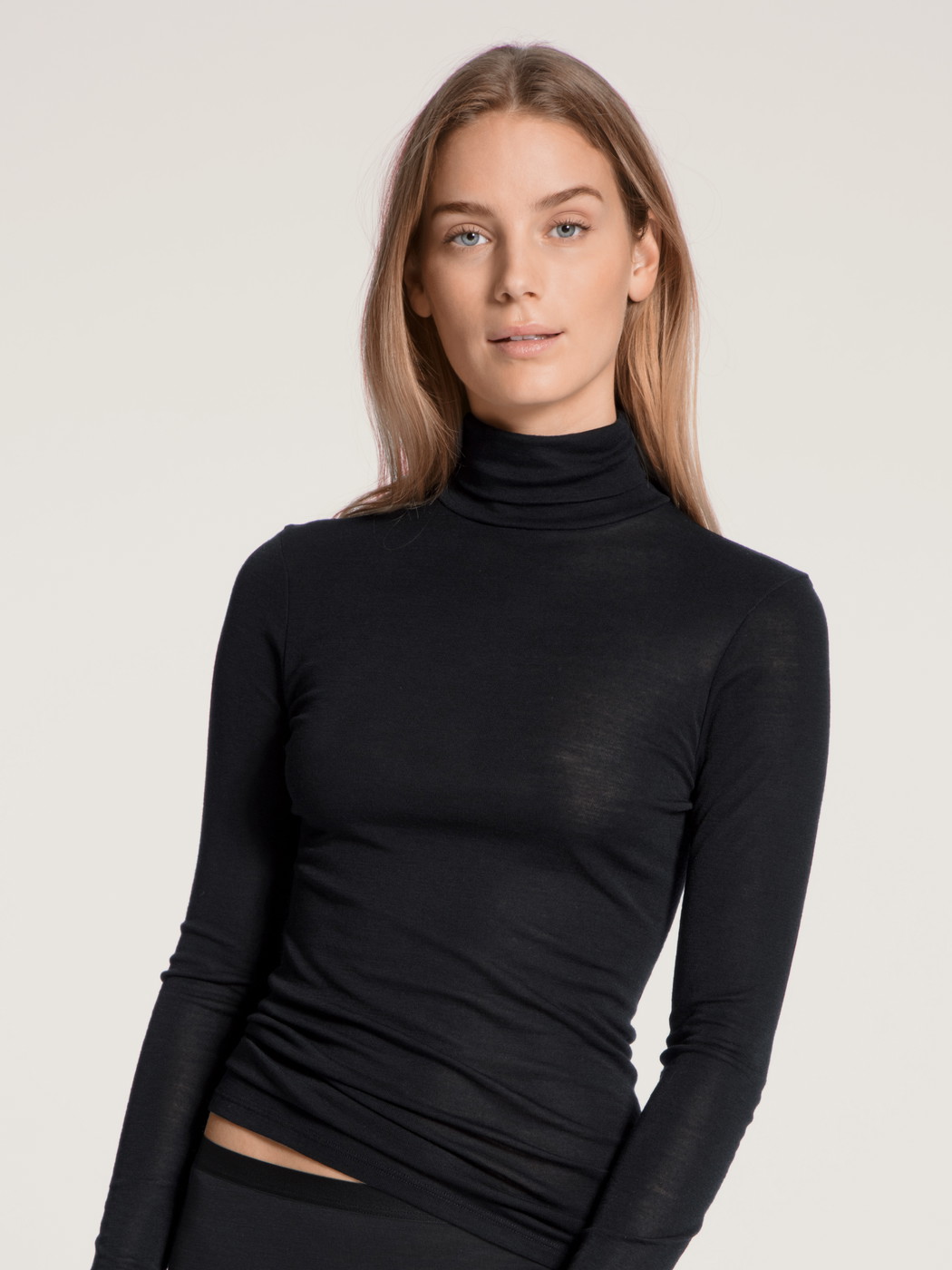 Le mannequin Femme porte le/la T-shirt à manches longues à col roulé en laine et soie en Laine de couleur Noir, Unicolore, de la série True Confidence de CALIDA, Vue de face