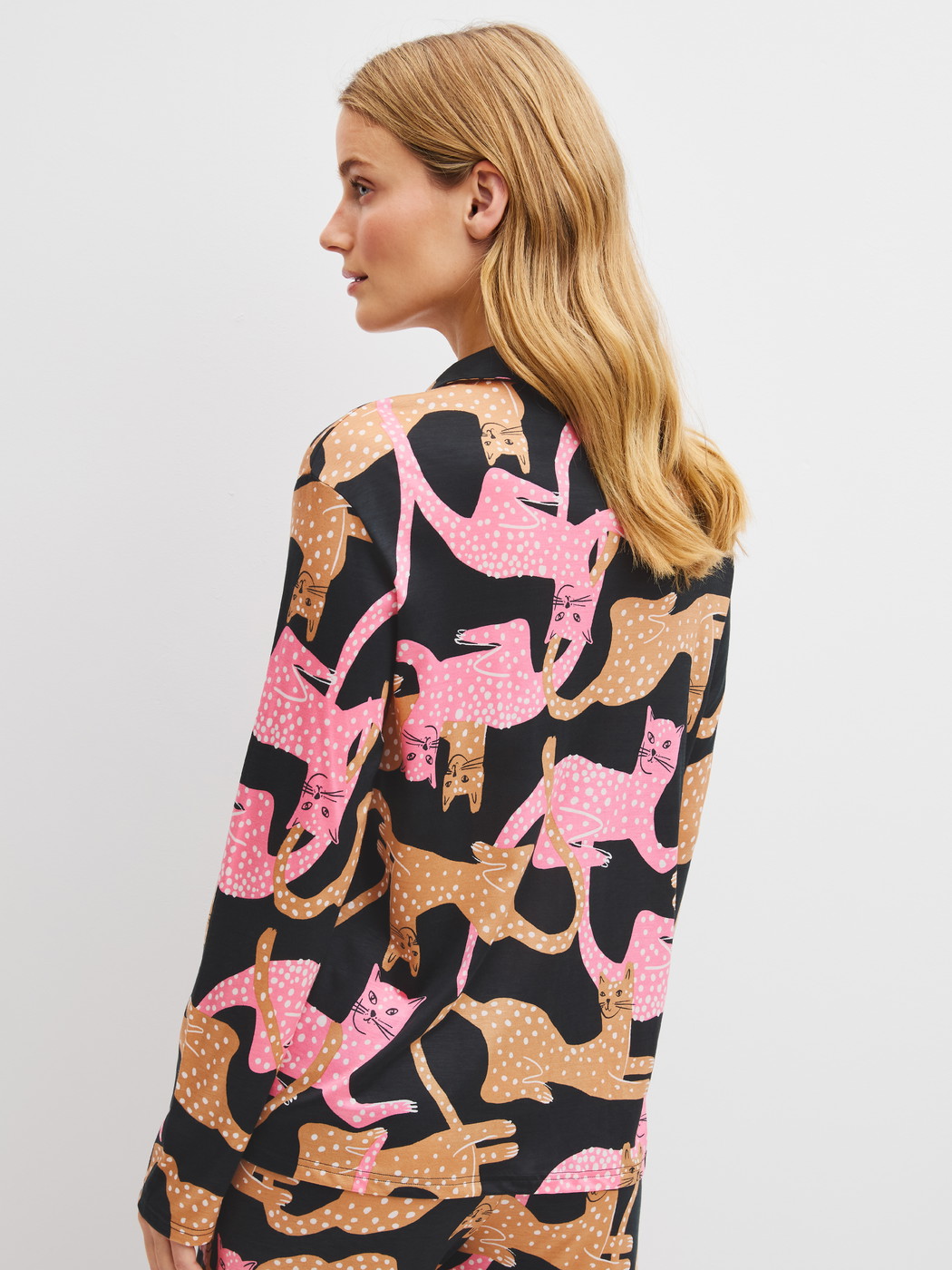 Damen-Model trägt Langarm-Shirt mit Knöpfen aus Modal in Schwarz, Motiv aus Serie Sleep Over M&M von CALIDA, Rückansicht