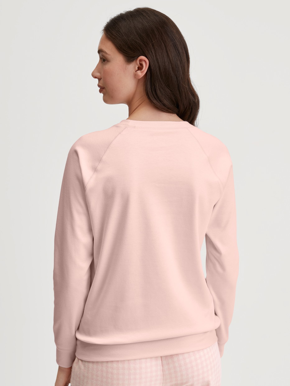 Damen-Model trägt Langarm-Shirt aus 100% Baumwolle in Rosa, Einfarbig aus Serie Favourites Universe von CALIDA, Rückansicht