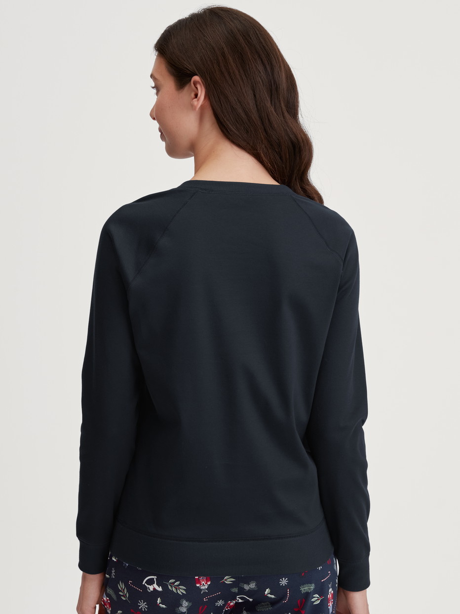 Damen-Model trägt Langarm-Shirt aus 100% Baumwolle in Blau, Einfarbig aus Serie Favourites Holidays von CALIDA, Rückansicht