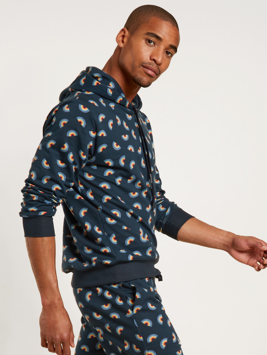 Herren-Model trägt Kapuzenpullover aus Baumwolle in Blau, Motiv aus Serie Love Capsule von CALIDA, Vorderansicht