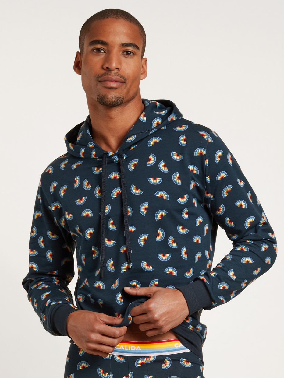 Herren-Model trägt Kapuzenpullover aus Baumwolle in Blau, Motiv aus Serie Love Capsule von CALIDA, Vorderansicht