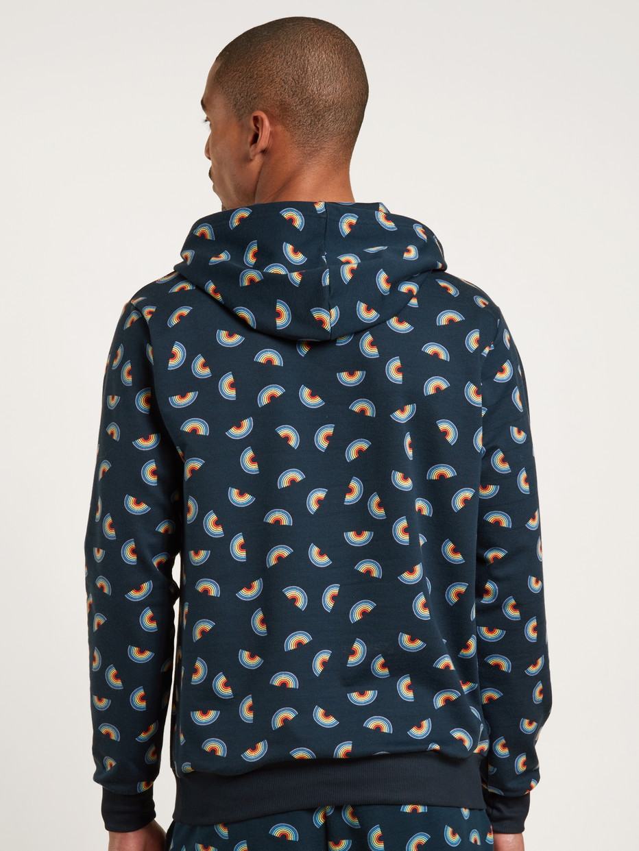Herren-Model trägt Kapuzenpullover aus Baumwolle in Blau, Motiv aus Serie Love Capsule von CALIDA, Rückansicht