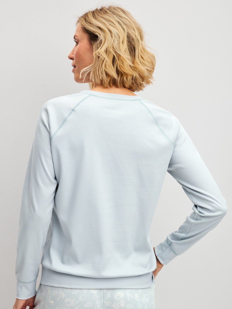 Damen-Model trägt Langarm-Shirt aus 100% Baumwolle in Blau, Einfarbig aus Serie Alpine M&M von CALIDA, Rückansicht