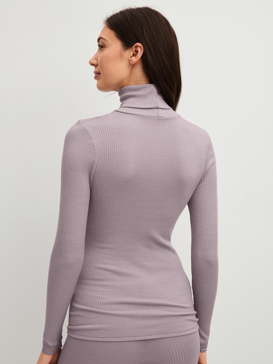 Damen-Model trägt Langarm-Shirt mit Rollkragen aus Wolle-Seide aus Wolle in Violett, Spitze aus Serie Silky Wool Joy von CALIDA, Rückansicht
