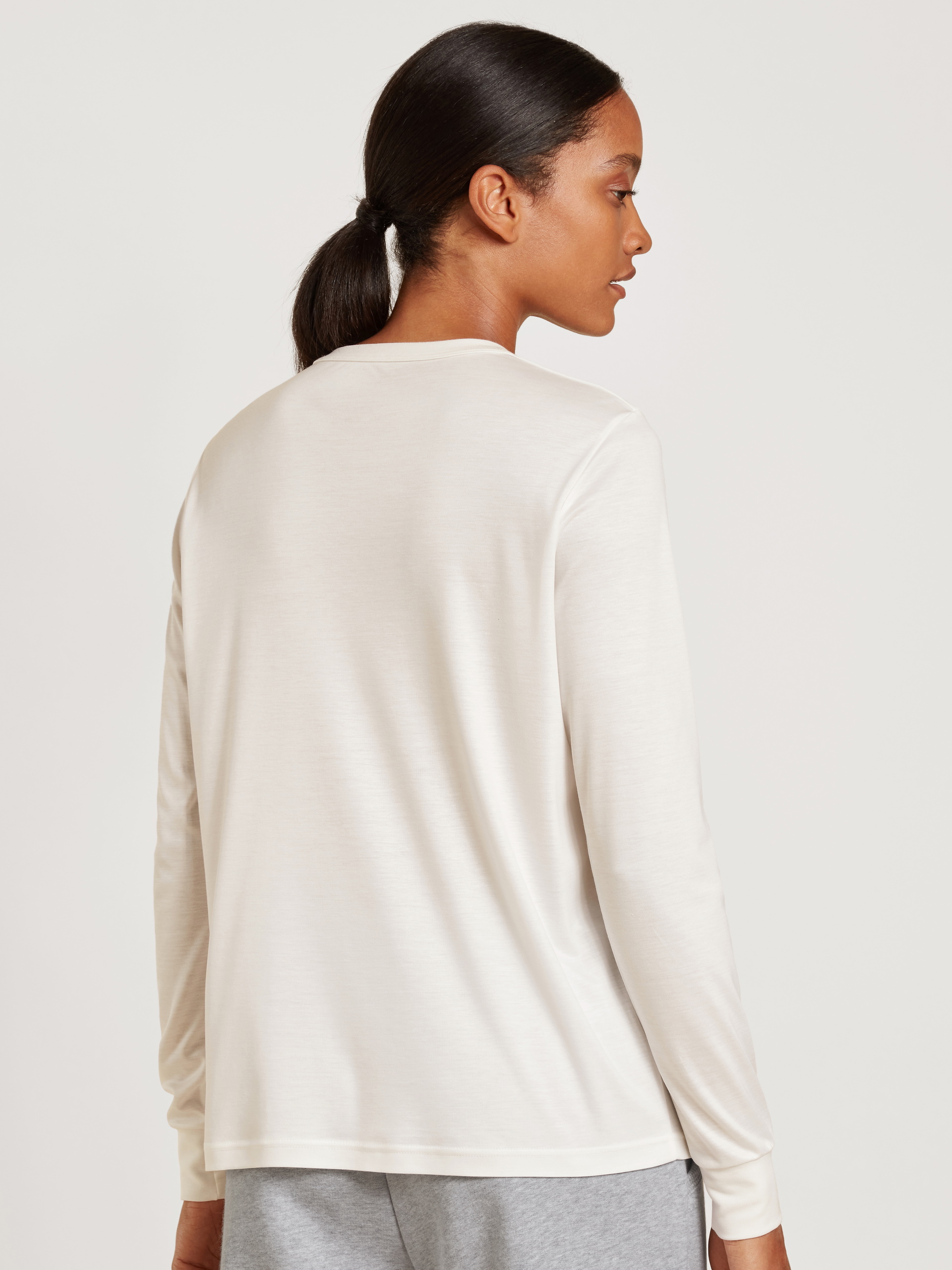 Damen-Model trägt Langarm-Shirt aus Modal in Weiß, Einfarbig aus Serie Lounge & Relax von CALIDA, Rückansicht