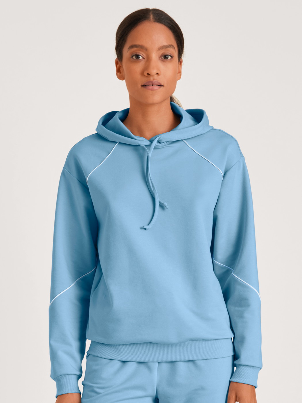 Damen-Model trägt Sweatshirt mit Kapuze aus Baumwolle in Blau, Einfarbig aus Serie Lounge Paisley von CALIDA, Vorderansicht