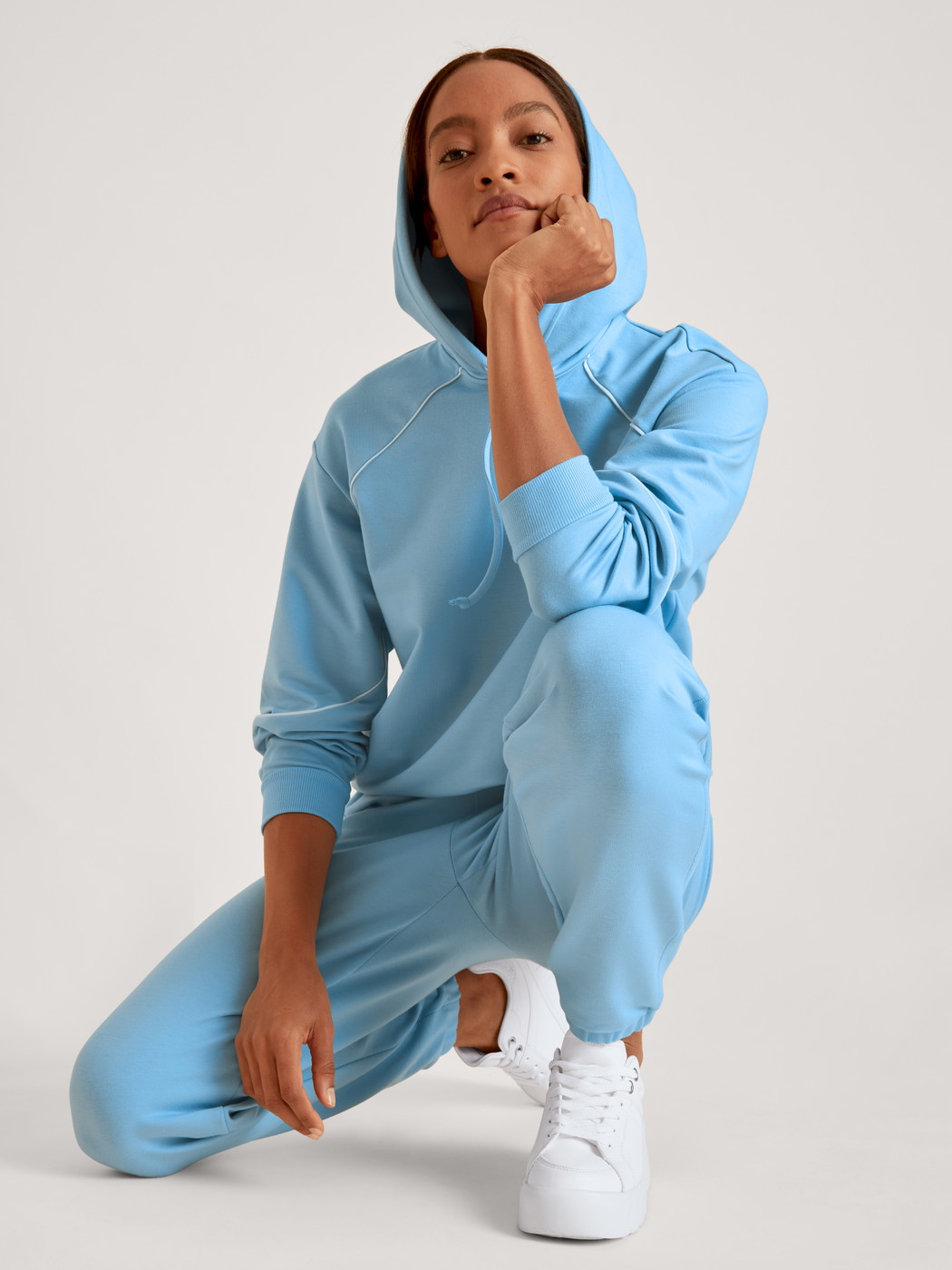 Damen-Model trägt Sweatshirt mit Kapuze aus Baumwolle in Blau, Einfarbig aus Serie Lounge Paisley von CALIDA, Vorderansicht, Outfit