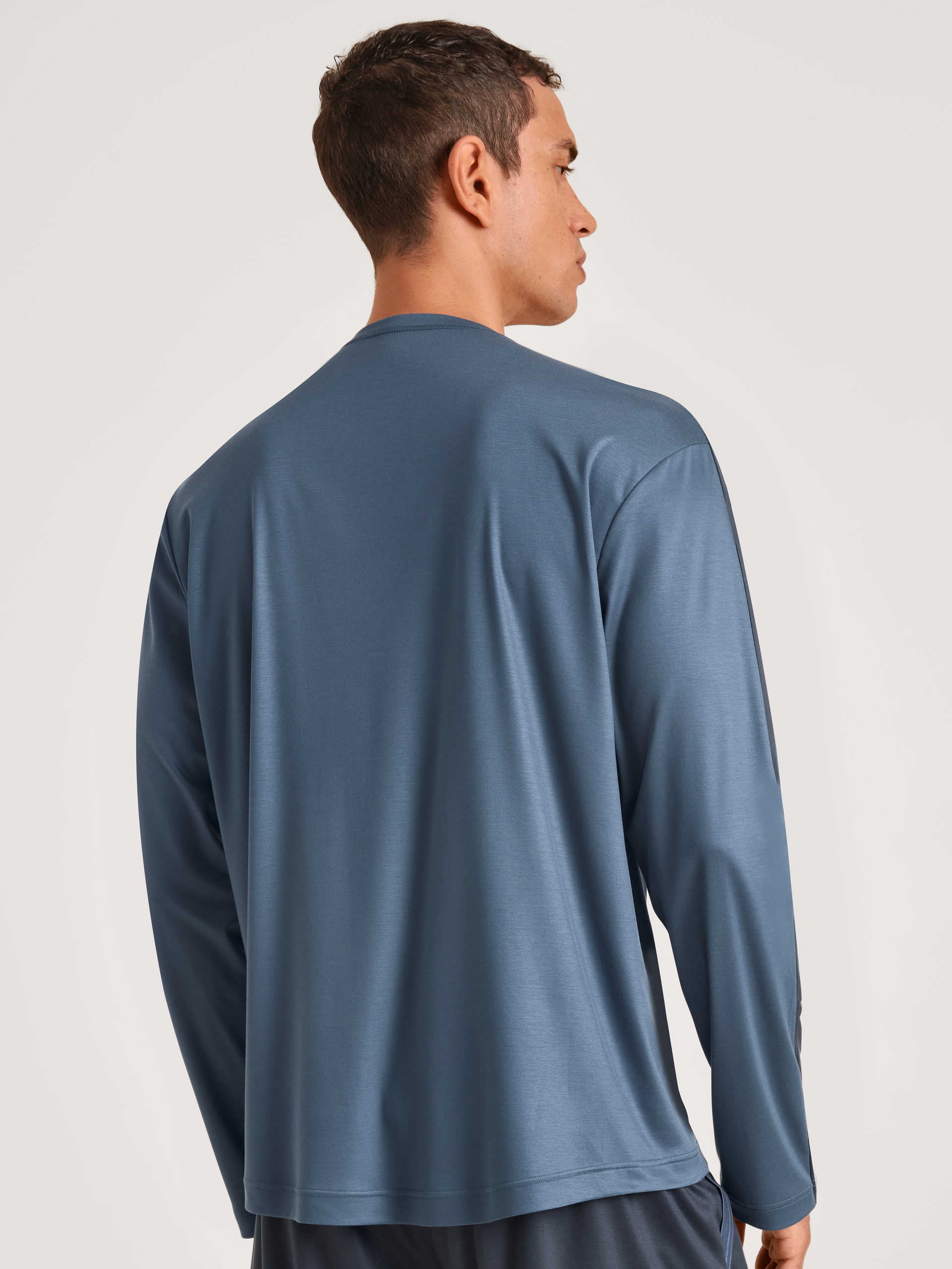 Men model is wearing Shirt long-sleeve made of Lyocell in Blue, Unicoloured from the DSW Cooling series by CALIDA, Back view