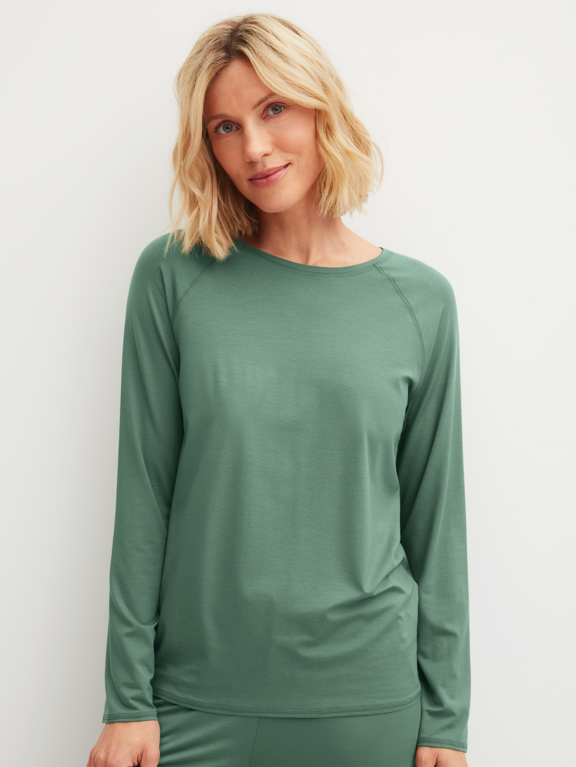 Damen-Model trägt Langarm-Shirt aus Modal in Grün, Einfarbig aus Serie DSW Balancing von CALIDA, Vorderansicht