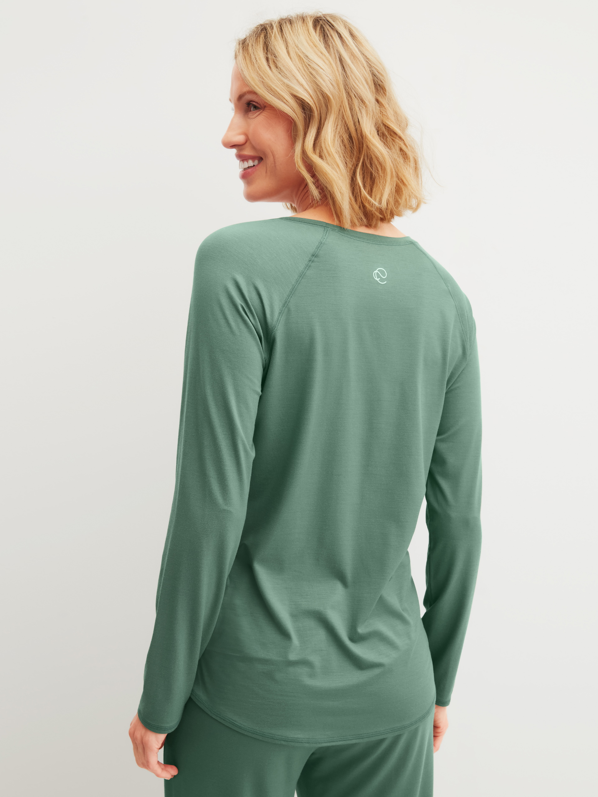 Damen-Model trägt Langarm-Shirt aus Modal in Grün, Einfarbig aus Serie DSW Balancing von CALIDA, Rückansicht