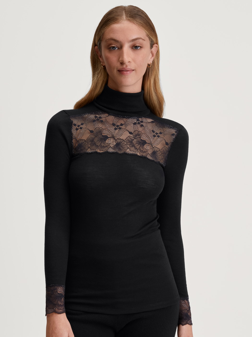 La modella / Il modello Donna indossa Maglia a maniche lunghe dolcevita in lana-seta in Pizzo di colore Nero, Pizzo, della serie Silky Wool Glam di CALIDA, Vista frontale