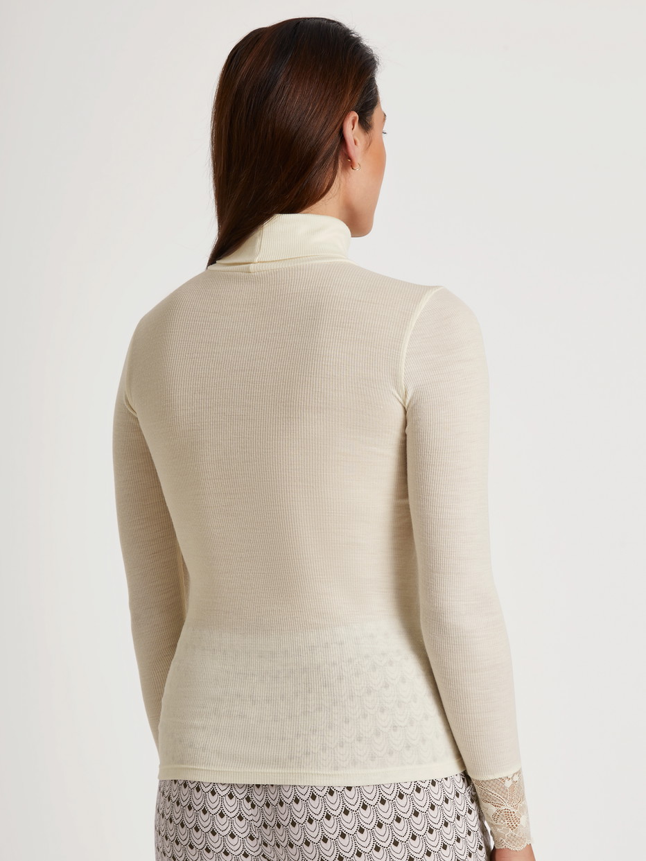 Damen-Model trägt Langarm-Shirt mit Rollkragen aus Wolle-Seide aus Wolle in Beige, Spitze aus Serie Silky Wool Glam von CALIDA, Rückansicht