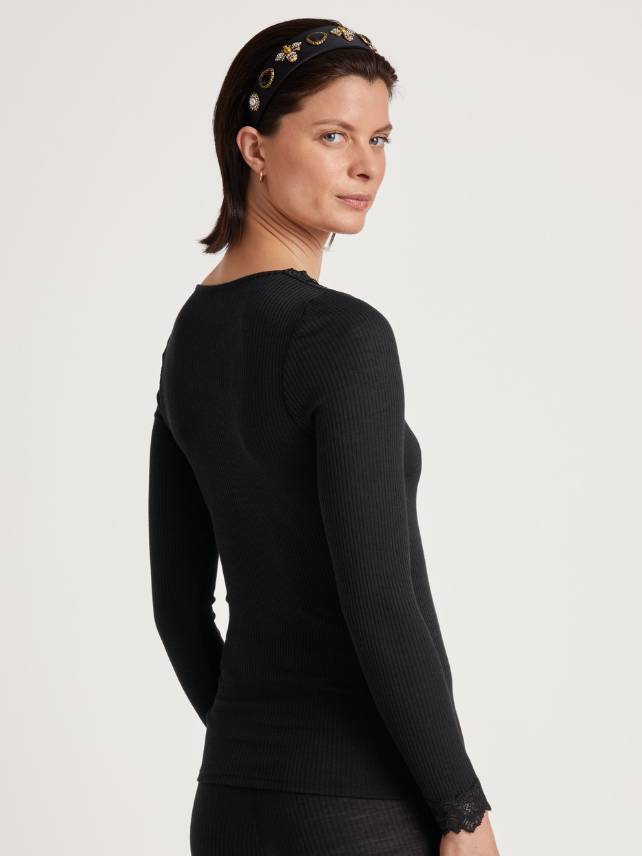 Damen-Model trägt Langarm-Shirt mit Wolle & Seide aus Wolle in Schwarz, Spitze aus Serie Silky Wool Joy von CALIDA, Rückansicht