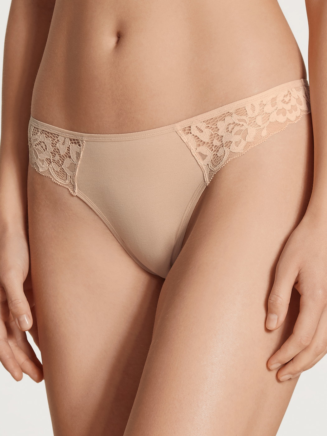 Damen-Model trägt String, low cut aus Baumwolle in Beige, Spitze aus Serie Natural Comfort Lace von CALIDA, Vorderansicht