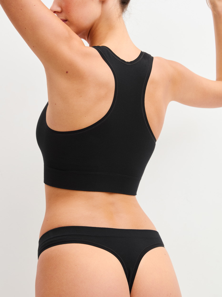Damen-Model trägt String aus Modal in Schwarz, Einfarbig aus Serie Seamless Natural von CALIDA, Zusatzbild