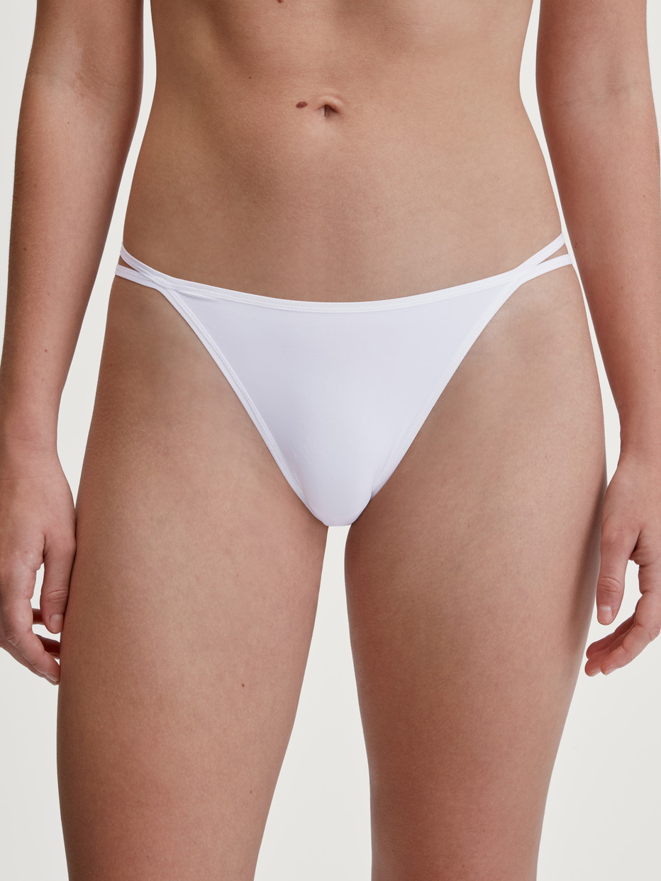 Damen-Model trägt Tanga-Slip, low cut aus Polyamid in Weiß, Einfarbig aus Serie Sleek Skin von CALIDA, Vorderansicht