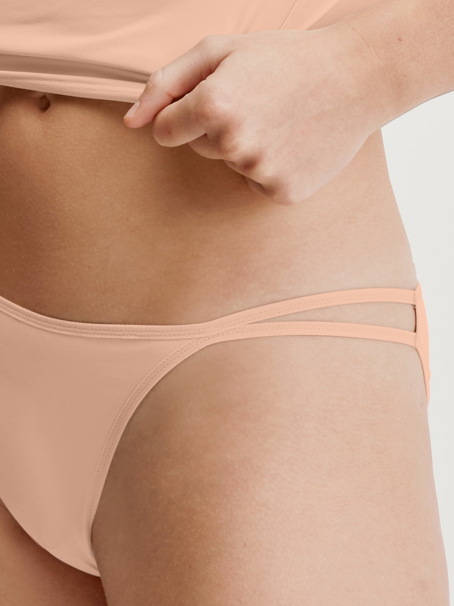 Damen-Model trägt Tanga-Slip, low cut aus Polyamid in Beige, Einfarbig aus Serie Sleek Skin von CALIDA, Detail