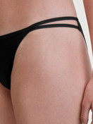 Women model is wearing Low Cut Tanga Brief made of Polyamide in Black, Unicoloured from the Sleek Skin series by CALIDA, Detail