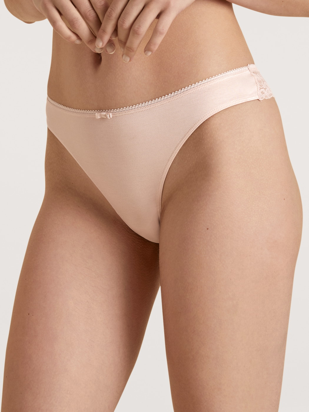 Damen-Model trägt String, low cut aus Viskose in Rosa, Spitze aus Serie Sensual Secrets von CALIDA, Vorderansicht