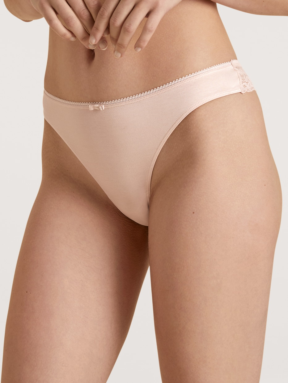 Damen-Model trägt String, low cut aus Viskose in Rosa, Spitze aus Serie Sensual Secrets von CALIDA, Vorderansicht