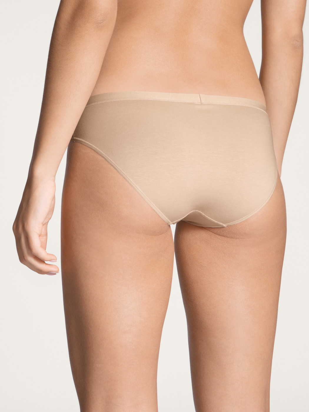 Damen-Model trägt Slip, low cut aus Baumwolle in Beige, Einfarbig aus Serie Natural Comfort von CALIDA, Rückansicht